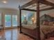 Serene main bedroom with hardwood floors, a canopy bed, and access to a private balcony at 205 Somerset Ct, Mcdonough, GA 30253