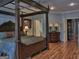 This main bedroom has hardwood floors, 2 doors and a large four-poster bed at 205 Somerset Ct, Mcdonough, GA 30253