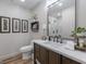 Modern bathroom featuring a marble countertop, dark wood cabinets, decorative lighting, and a framed mirror at 111 S Old 27, Roopville, GA 30170
