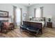 Bright bedroom with a wooden sleigh bed, soft furnishings, and a cozy seating area by the window at 111 S Old 27, Roopville, GA 30170