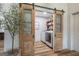 Convenient laundry area with a sliding barn door and modern washer and dryer at 111 S Old 27, Roopville, GA 30170