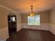 Dining room with dark wood floors, decorative wainscoting, and classic chandelier at 257 Juliet Dr, Hampton, GA 30228