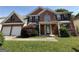 Traditional brick home featuring a two-car garage, manicured lawn, and covered front porch at 257 Juliet Dr, Hampton, GA 30228