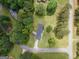 An aerial view shows the home's setting on a large, lush green lot surrounded by mature trees at 105 Greenfield Cir, Fayetteville, GA 30215