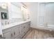 Bright bathroom features a double vanity, wood-look floors and ample natural light at 105 Greenfield Cir, Fayetteville, GA 30215