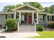 Inviting covered front porch with decorative plants and a bright red door at 105 Greenfield Cir, Fayetteville, GA 30215