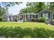 Charming single-story home with gray siding, black shutters, a well-manicured lawn, and inviting front porch at 105 Greenfield Cir, Fayetteville, GA 30215