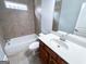 Bathroom featuring a tub and shower, neutral colored tile, a toilet, a sink and vanity at 625 Chestnut St # D, Hapeville, GA 30354