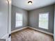 Bedroom with neutral colored walls, carpet, two windows with blinds, and a door at 625 Chestnut St # D, Hapeville, GA 30354