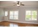 Bright living room with hardwood floors, two windows with blinds, and a ceiling fan with a light fixture at 625 Chestnut St # D, Hapeville, GA 30354