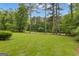 Large, grassy backyard with mature trees and a fence along the back property line at 105 Gleneagles Pt, Peachtree City, GA 30269