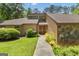 Close-up of the home's entrance, featuring a unique front door, well-kept lawn and mature shrubs at 105 Gleneagles Pt, Peachtree City, GA 30269