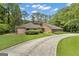 Inviting single-story home featuring a long driveway and lush green lawn surrounded by mature trees at 105 Gleneagles Pt, Peachtree City, GA 30269