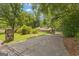 Exterior view of the single-story home, surrounded by mature trees with a long driveway at 105 Gleneagles Pt, Peachtree City, GA 30269