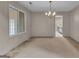 Carpeted living room with a view to the sunroom and a hanging chandelier at 105 Gleneagles Pt, Peachtree City, GA 30269
