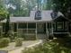 Charming home featuring a cozy front porch, well-maintained lawn, and mature trees at 686 Favorwood Sw Dr, Marietta, GA 30060