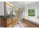Bright bathroom featuring a tub, glass shower, double vanity, and tile flooring at 3924 Lorien Nw Way, Kennesaw, GA 30152