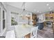 Bright dining area with a white table, chandelier, and large window showcasing the lush greenery outside at 3924 Lorien Nw Way, Kennesaw, GA 30152
