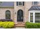 Charming brick home featuring black double doors, complementary black shutters, and lush landscaping at 3924 Lorien Nw Way, Kennesaw, GA 30152