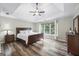 Bright main bedroom with hardwood floors, a tray ceiling, and lots of natural light from a large window at 3924 Lorien Nw Way, Kennesaw, GA 30152