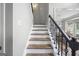 Elegant staircase with wood treads, iron railing, and an open view into the dining area at 3924 Lorien Nw Way, Kennesaw, GA 30152