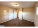 Beige bedroom with two windows, carpeted floor, and open closet at 4366 Glenwood Pkwy, Decatur, GA 30032