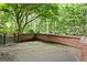 Outdoor brick patio area featuring a brick privacy wall, overlooking a lush wooded area at 3571 Lake Se Dr, Smyrna, GA 30082