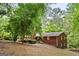 Brick home exterior, mature trees and landscaped yard in a serene backyard setting at 3571 Lake Se Dr, Smyrna, GA 30082