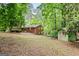 A quaint brick home with a charming backyard and storage shed nestled among mature trees at 3571 Lake Se Dr, Smyrna, GA 30082