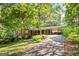 Charming brick home with a red front door and a covered carport surrounded by lush greenery at 3571 Lake Se Dr, Smyrna, GA 30082