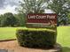 Lake Court Park sign with flower emblem in a grassy, tree-filled environment at 3571 Lake Se Dr, Smyrna, GA 30082