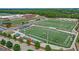 Vibrant aerial view of athletic fields, stadium, and school buildings surrounded by lush greenery at 3823 Heritage Pl, Buford, GA 30519