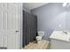 Clean, neutral bathroom with white fixtures and a shower with a patterned curtain at 3823 Heritage Pl, Buford, GA 30519