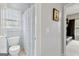This is a bright bathroom with a toilet and a shower with a floral curtain next to a window at 3823 Heritage Pl, Buford, GA 30519