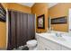 Bathroom featuring a white vanity with sink, a dark shower curtain, and warm-toned walls at 3823 Heritage Pl, Buford, GA 30519