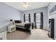 Cozy bedroom with a ceiling fan, carpet, and two sunny windows dressed with elegant black curtains at 3823 Heritage Pl, Buford, GA 30519