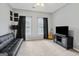 This is a bedroom or flex space with a black futon, carpet, and great natural light at 3823 Heritage Pl, Buford, GA 30519