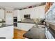 Bright kitchen with white cabinets, black countertops, and stainless steel appliances at 3823 Heritage Pl, Buford, GA 30519