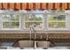 Close up of stainless steel sink with tiled backsplash and bright natural light at 3823 Heritage Pl, Buford, GA 30519