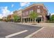 Exterior view of a commercial street with a variety of storefronts, trees, and brick sidewalks at 3823 Heritage Pl, Buford, GA 30519