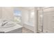 Bright bathroom featuring a double vanity, soaking tub, and a glass enclosed shower at 1940 Van Allen Ct # 12, Dacula, GA 30019