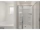 Modern bathroom showcasing a glass-enclosed shower and a luxurious soaking tub with a window at 1940 Van Allen Ct # 12, Dacula, GA 30019