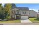 Charming two-story home featuring a combination of brick and siding, a two-car garage, and a well-manicured front lawn at 1940 Van Allen Ct # 12, Dacula, GA 30019