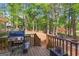 Deck featuring a grill with views of the wooded backyard and lake in the distance at 226 Le Paradis Blvd, Sharpsburg, GA 30277
