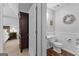 Hallway view of a well-lit half-bathroom and bedroom with an open door at 226 Le Paradis Blvd, Sharpsburg, GA 30277