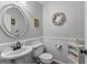 Charming half bathroom boasts a pedestal sink, wainscoting, and decorative details at 226 Le Paradis Blvd, Sharpsburg, GA 30277
