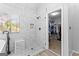 Bright bathroom features a glass-enclosed shower, a window, and an open walk-in closet at 226 Le Paradis Blvd, Sharpsburg, GA 30277