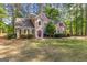 A cozy two-story home is surrounded by mature trees and a vibrant green lawn at 226 Le Paradis Blvd, Sharpsburg, GA 30277