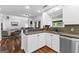 Modern kitchen featuring white cabinets, stainless steel appliances, and wood flooring, open to the living room at 226 Le Paradis Blvd, Sharpsburg, GA 30277