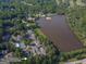 Drone shot of community near the lake, showcasing manicured landscaping, pool, tennis court and ample parking at 701 Ridgelake Dr, Peachtree City, GA 30269